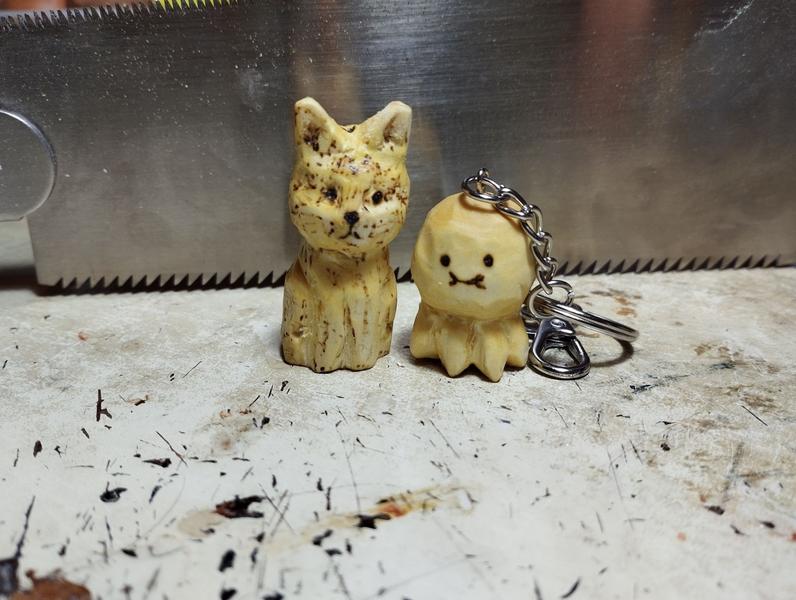Un chat en bois, un peu tigré et un porte clés poulpe, très arrondi, avec des petits tentacules 