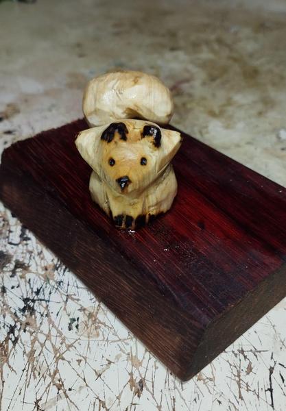 Un renard en bois avec une grande queue courbée