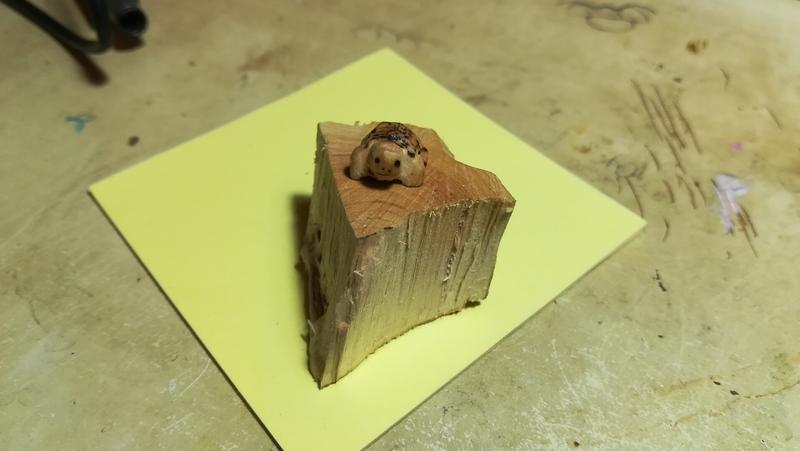 Petite sculpture de tortue, on voit sa tête qui sourit 