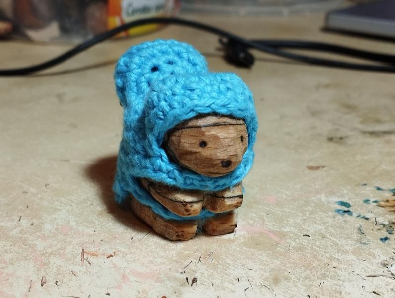 Un écureuil en bois vêtu d'un manteau bleu