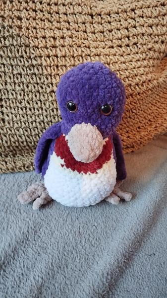 Un manchot au crochet. Son corps est violet et blanc 