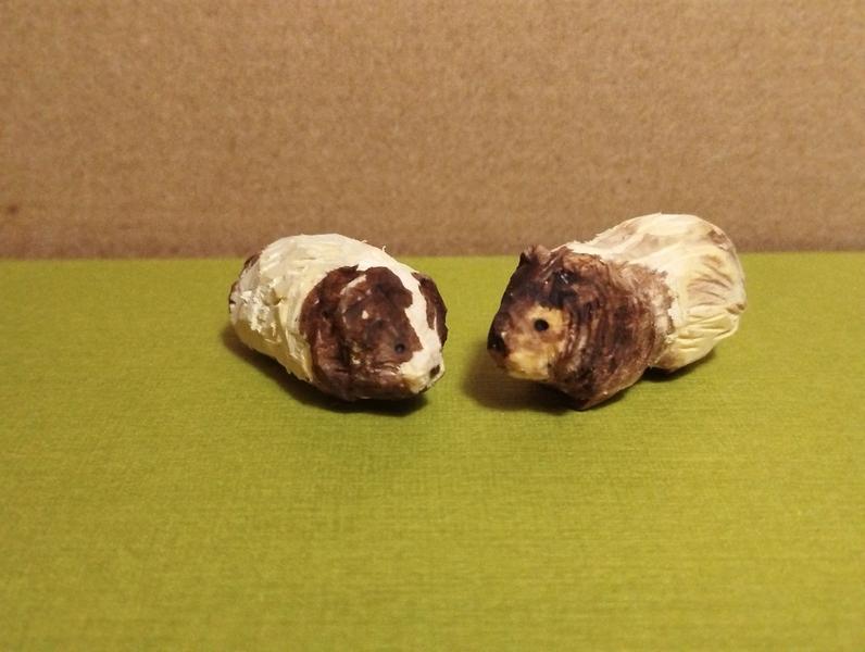 Deux cochons d'inde en bois. La texture donne un peu l'impression que les poils sont longs