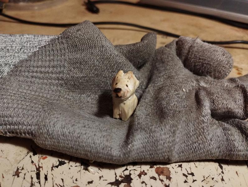 Petite sculpture de chien assis avec un long museau 