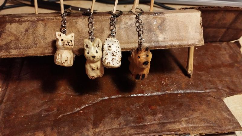 4 marqueurs de maille avec des pendentifs en bois : un chat, un lapin, un hérisson et un renard 