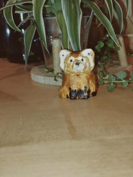 Sculpture en bois d'un panda roux assis