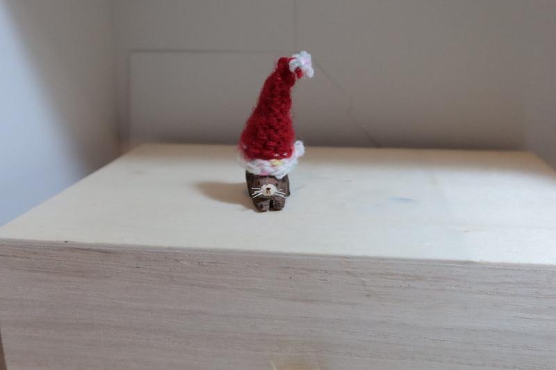 sculpture en bois d'un ragondin avec un grand bonnet de noël crocheté sur sa tête