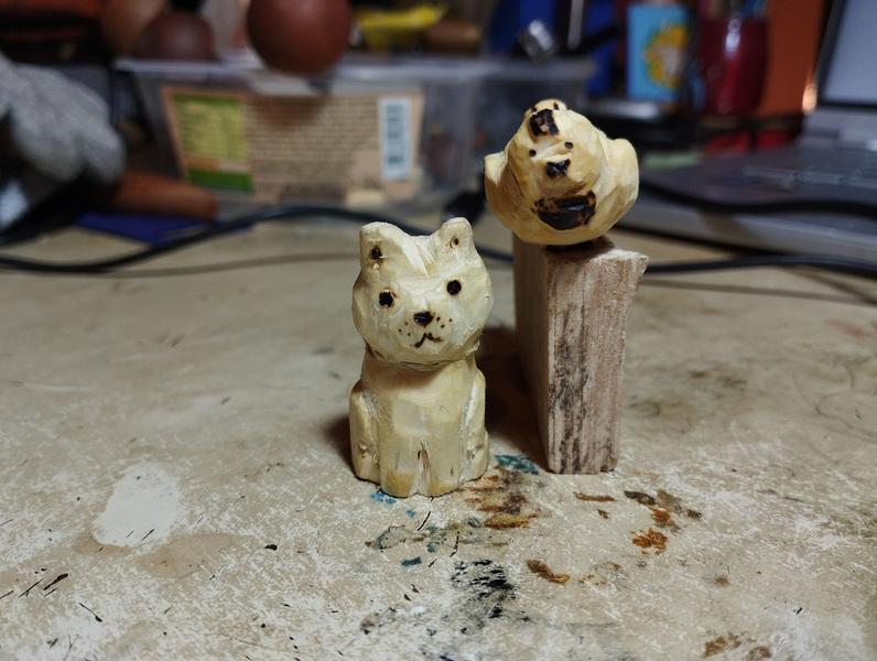 Un chat et une poule en bois qui regarde l'objectif 