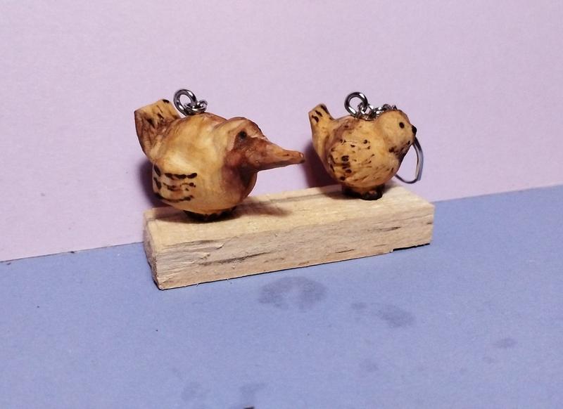2 oiseaux en bois. Ils sont très arrondis. Celui de gauche a un bec de canard 
