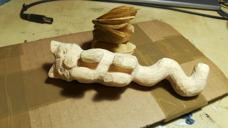 sculpture de chat avec une aile faite avec des fruits d'érable, vue de face