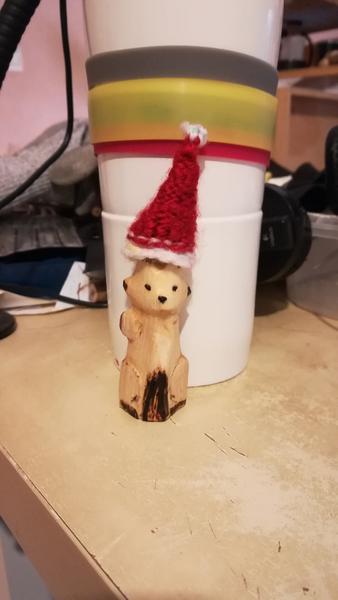 sculpture en bois de renard portant un bonnet de noël crocheté