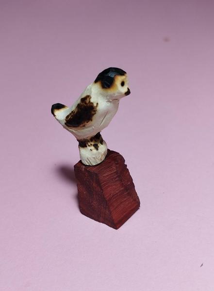 Un petit oiseau en bois, noir et blanc