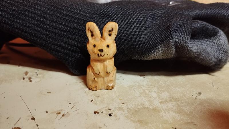 Un petit lapin en bois, debout sur ses pattes arrières 