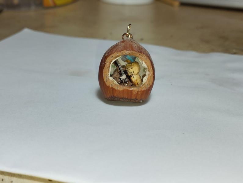 Pendentif noisette avec un chat qui joue de la contrebasse en tenant l'archet