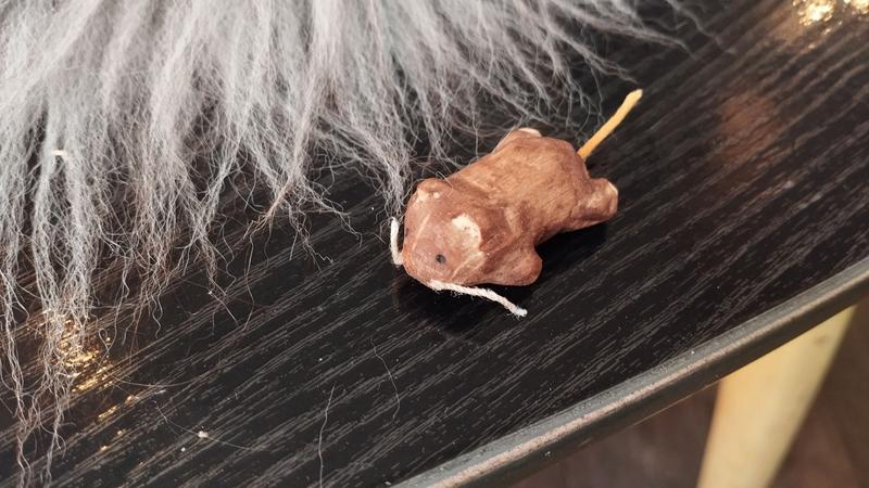 La sculpture de rat à côté de poils de chat