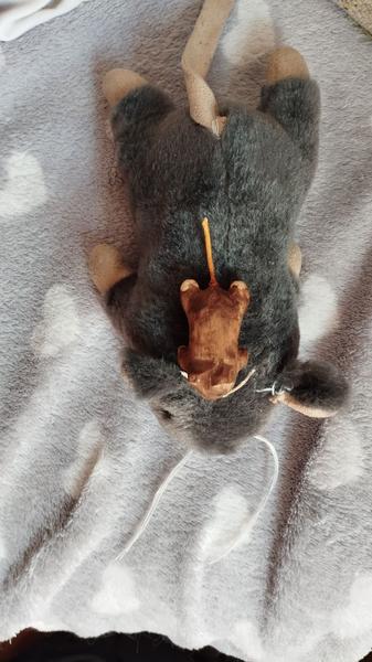 Un petit rat/taupe en bois posé sur son équivalent en peluche. Vus de dessus