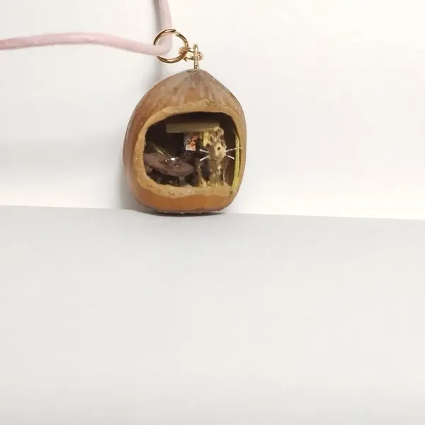 Pendentif noisette avec un chat dedans 