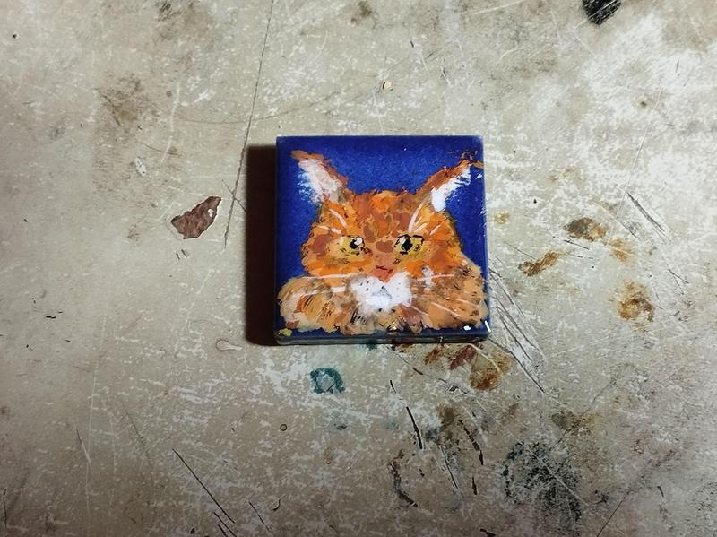 Dessin d'un chat rouge sur un carré de mosaïque bleu marine