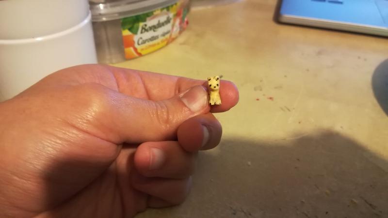 mini sculpture de chien tenue du bout des doigts