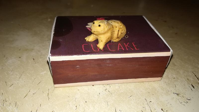 sculpture de crapaud en bois sur une boite d'allumettes