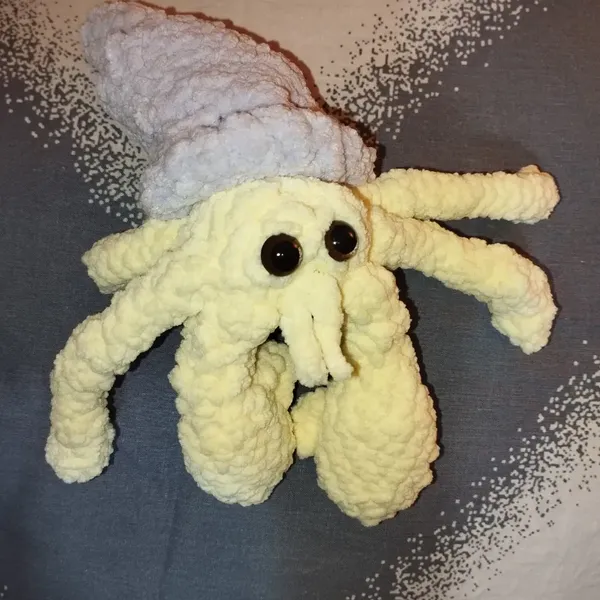 Un Bernard l'hermite au crochet, corps jaune, coquillage violet 