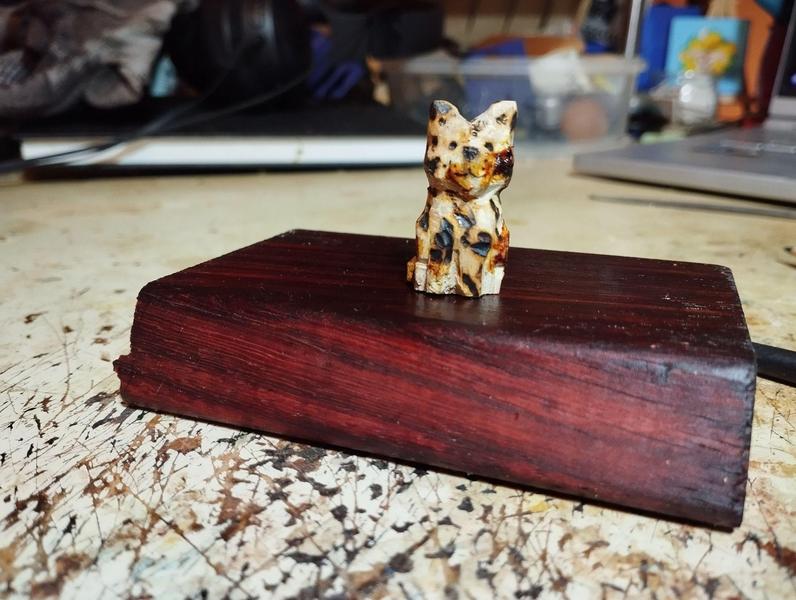 Une petite sculpture de chat calicot en bois