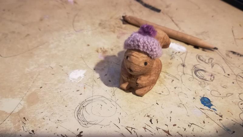 Sculpture d'écureuil portant un bonnet crocheté avec un pompon 