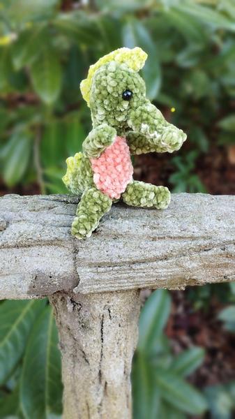 Un alligator au crochet, assis sur une rembarde